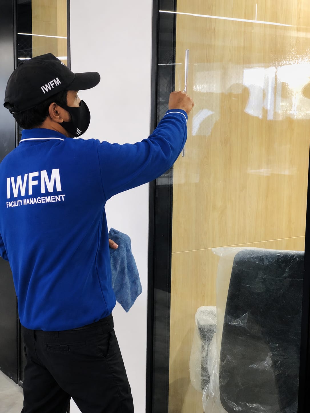 IWFM staff cleaning interior glass doors